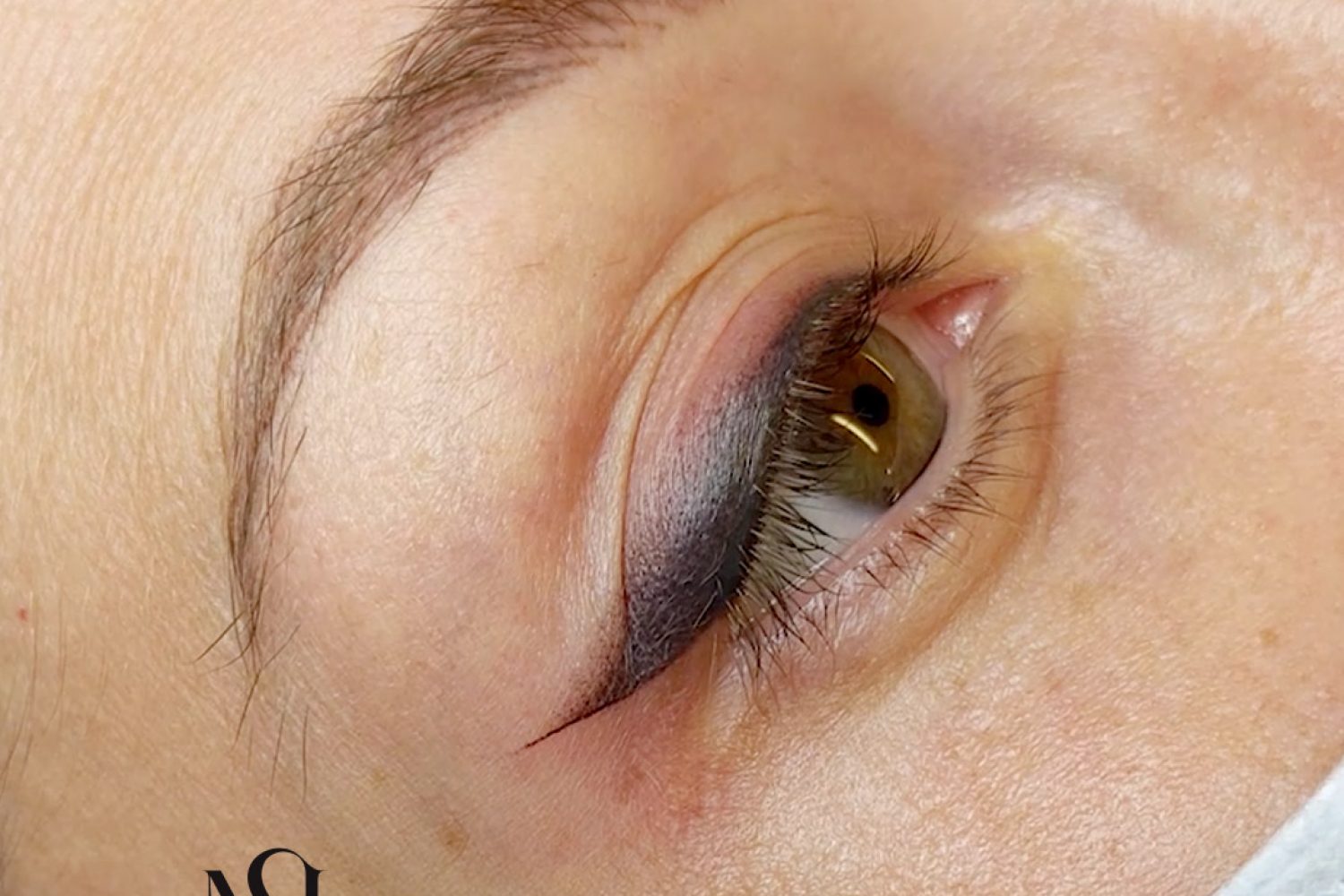 eyeliner sfumato per correggere un tatuaggio più vecchio eseguito da più di un operatore.